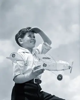 Balsa: Smiling Young Boy Shading Eyes with Hand Looking