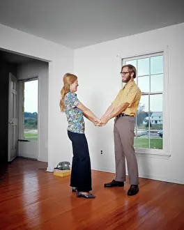 Ecstatic: Smiling Young Couple Holding Hands in Their Empty