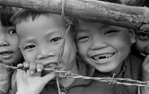 Dien: Smiling youngsters press against a barbed ?