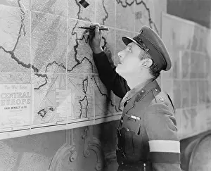 Ponder: Soldier looking at a map marking it with a pen