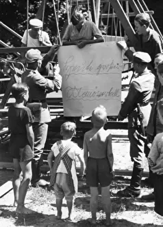 Advertises: Soldiers mount a poster, 1935