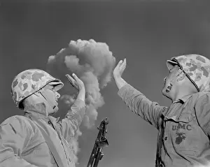 Fission: Soldiers pose below an atomic cloud at the Nevada