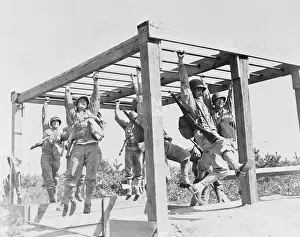 Exercising: Soldiers swinging across horizontal ladders