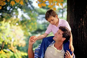 Parenthood: Son Sitting on Father's Shoulders Looking at Each