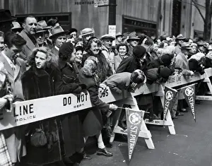 Descendents: Spectators lean over barricades to watch the