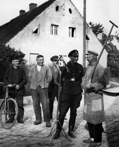 Scythe: SS man interviewing a farmer, 1933