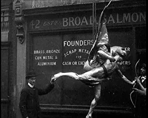 Lifted: A Statue Of Eros Being Lifted Up By A Crane