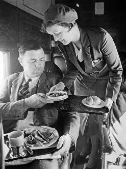 Purser: Stewardess serving dinner aboard an airplane, 1932