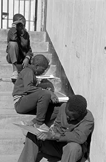 Ngos: Street children doing school work on steps outside