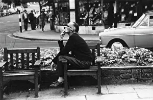 Belisha: Street scene with man smoking on a bench