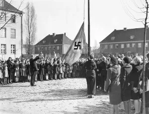 Primary: Students and teachers take down the swastika flag, 1939