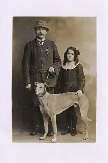 Greyhounds: Studio portrait, father and daughter with greyhound