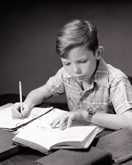 Studious: Studious Boy at Home Desk Doing Homework Reading Textbook nao