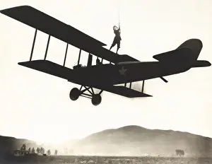 Mid Air: Stunt woman standing on top of biplane