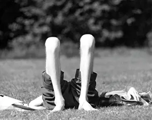 Sunbathes: Sunbathing on grass rolled up trousers knees in the air