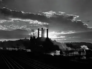 Generate: Sunrise sunset behind silhouette of industrial