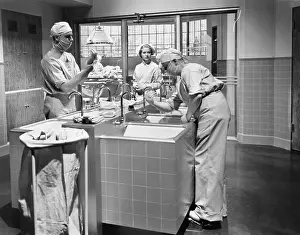 Scrub: Two surgeons and a nurse in the scrub room preparing