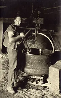 Fondue: Swiss Cheesemaker stiring a large vat