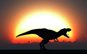 Howling: A T Rex silhouetted against the setting Sun at the end of a