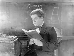 Blackboards: Teacher holding a book in front of a black board