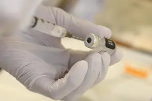 Lcgr2021: A technician loads a syringe with COVID-19 vaccine