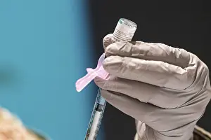 Lcgr2021: A technician loads a syringe with the Pfizer-BioNTech