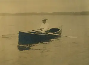Theodore Roosevelt, seated in rowboat, rowing