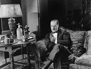 Brood: Thoughtful man having a drink on couch