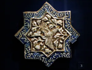 Calligraphy: Tile with phoenix and Quranic text. Iran. 1275-1325. Moulded
