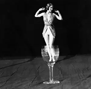 Shrunk: Tiny woman standing in wineglass