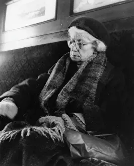 Tired elderly woman sleeping on a train