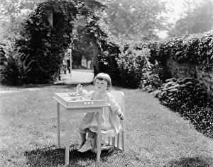 Wholesome: Toddler eating at table in garden