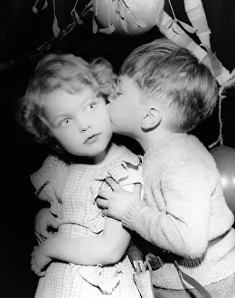 Kisses: Two toddlers under the mistletoe