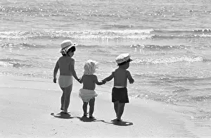 Caring: Three tots on beach, Tenby