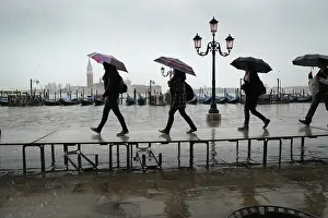 Dunn: Tourists carrying umbrellas on temporary walkway, Venice