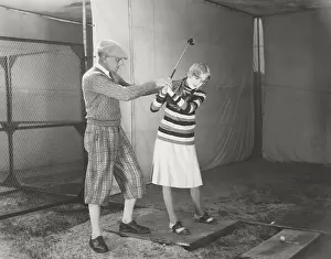 150724: Trainer teaching woman to play golf
