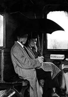 Compartment: Travelers with an open umbrella in a train compartment