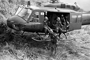 Unloading: Troops make an air assault from a UH-1 Huey into