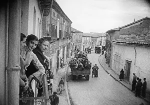 Passer: Troops marching through a Spanish village, 1936