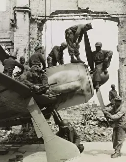 Removing: Troops removing pieces from a grounded fighter