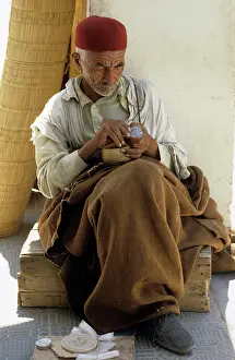 Trinkets: Tunisian man sits in shade