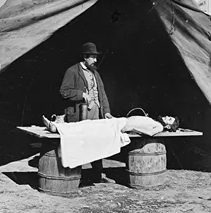 Embalming: Unknown location. Embalming surgeon at work on soldier's bod