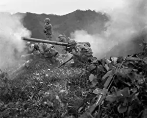 75mm: U.S. Army gunner (crouching foreground), fires