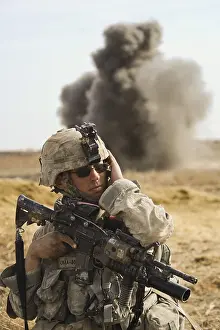 Helmand: U.S. Army soldier with covers his ear as ?