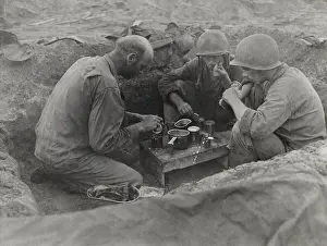 Forager: Three U.S. Army soldiers eat rations in a foxhole