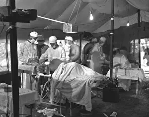 Thru: U.S. Navy doctors and corpsmen operate on two