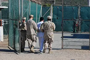 Detainee: U.S. Navy guards escort a detainee through ?