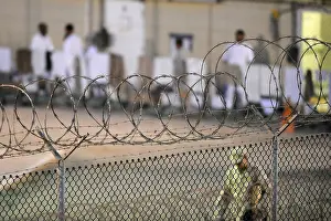 Guantanamo: A U.S. Sailor foreground conducts an early ?