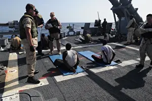 Restraints: U.S. Sailors guard suspected pirates on ?