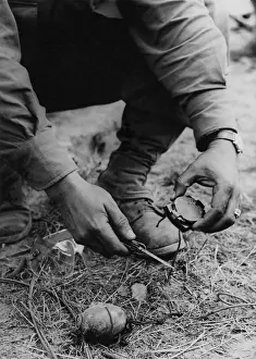 Booby: U.S. soldier dismantles a German booby trap planted